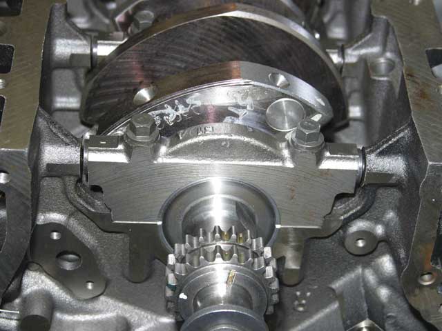 Close-up photo of crankshaft, main cap and timing gears in engine block