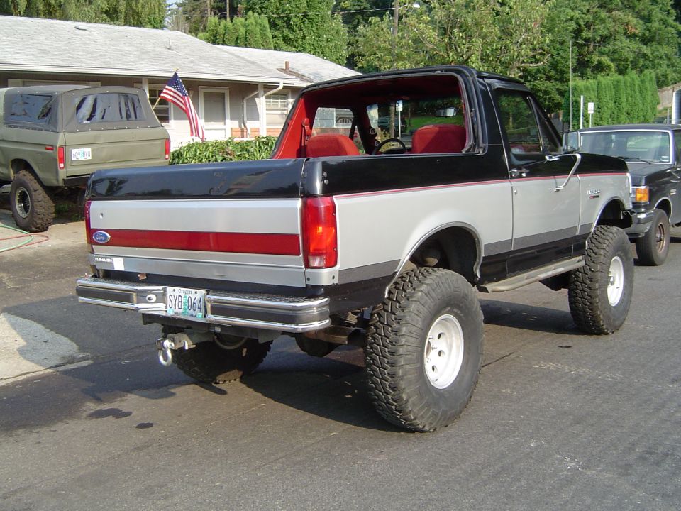 Lifted black and silver Ford Bronco rear three-quarter view with red interior
