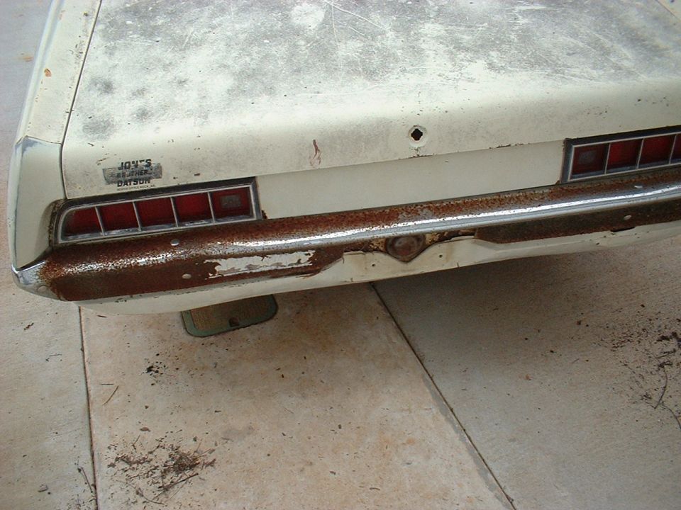 Rear view of a rusty 1970 Ford Falcon with a Datsun sticker