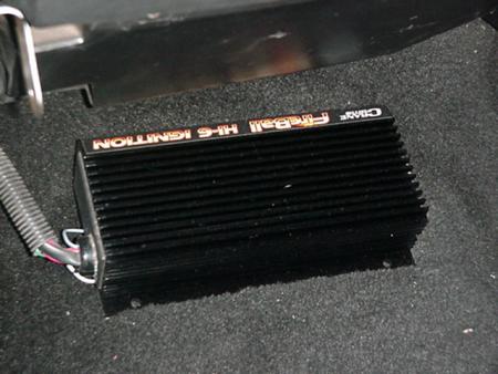 1979 Ford Bronco - A black ignition control module with orange lettering is visible on a carpeted floor.