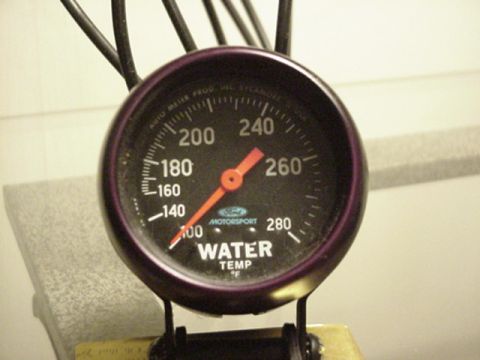 1979 Ford Bronco - A close-up of a water temperature gauge with an orange needle pointing to approximately 220 degrees Fahrenheit.