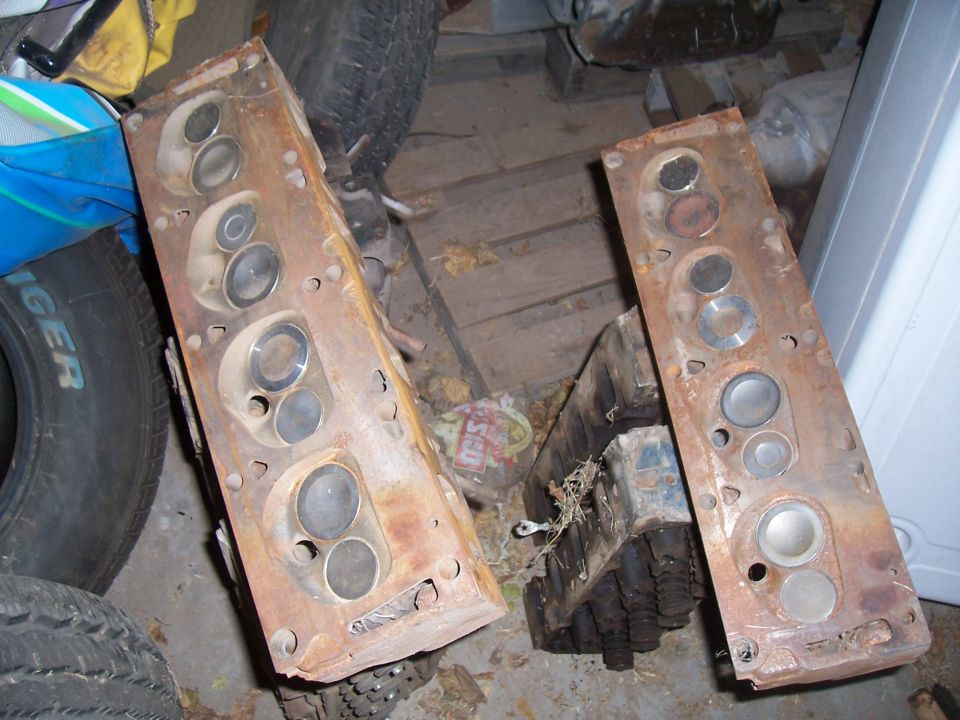 Two cylinder heads showing combustion chambers next to tires