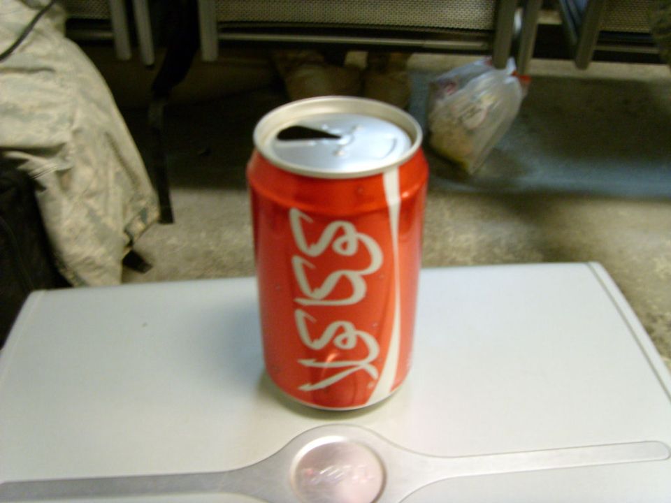 Can of Coca-Cola with foreign-script lettering on a white table
