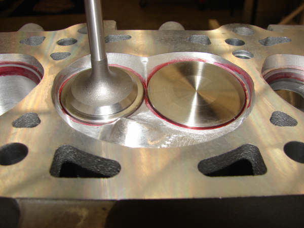 Close-up photo of intake and exhaust valves in a cylinder head chamber