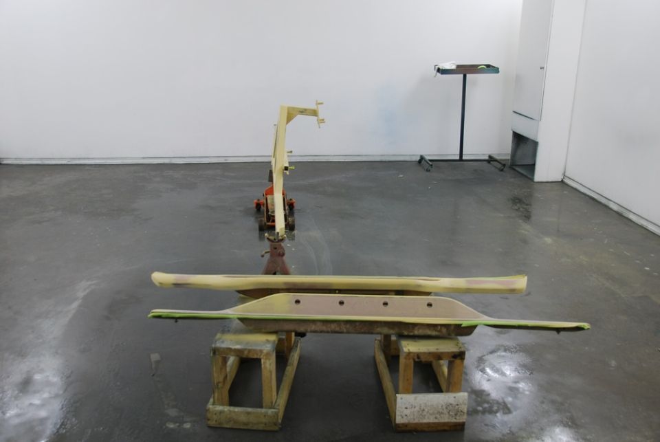 Primed automotive body panel on sawhorses in a paint shop