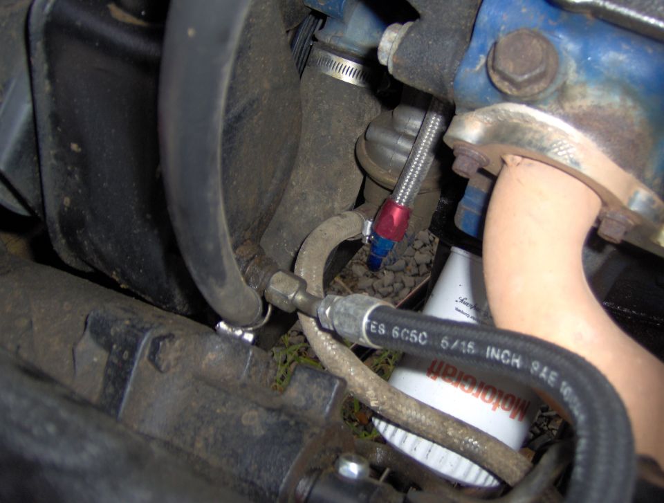 Engine bay with hoses, metal lines, and Motorcraft oil filter in a 1978 Ford Bronco.