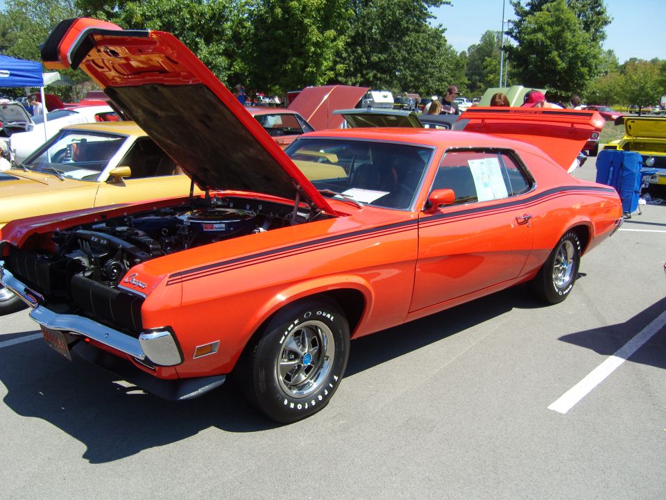 Orange 1969-70 Mercury Cougar with hood open at an outdoor car show