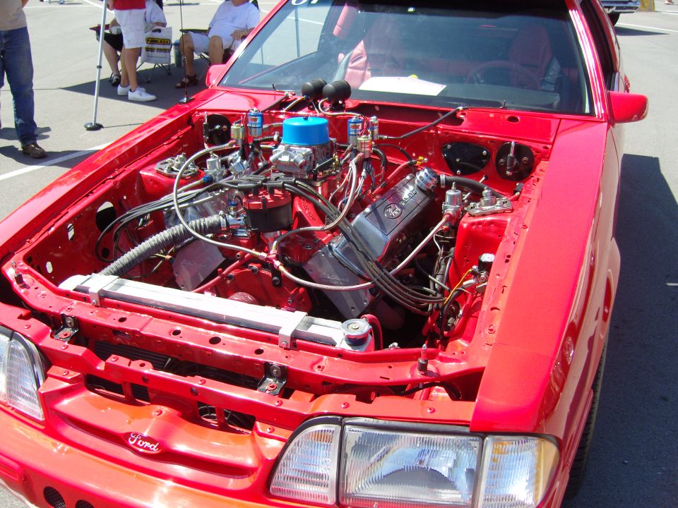 Red Fox-body Mustang race car engine bay with dual carburetors, hood off