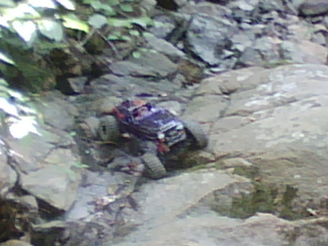 Purple RC rock crawler on rocky terrain
