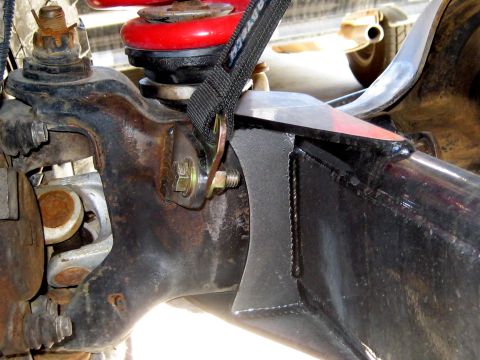 1996 Ford Bronco - Close-up view of vehicle suspension parts, showing rust and a securing strap.