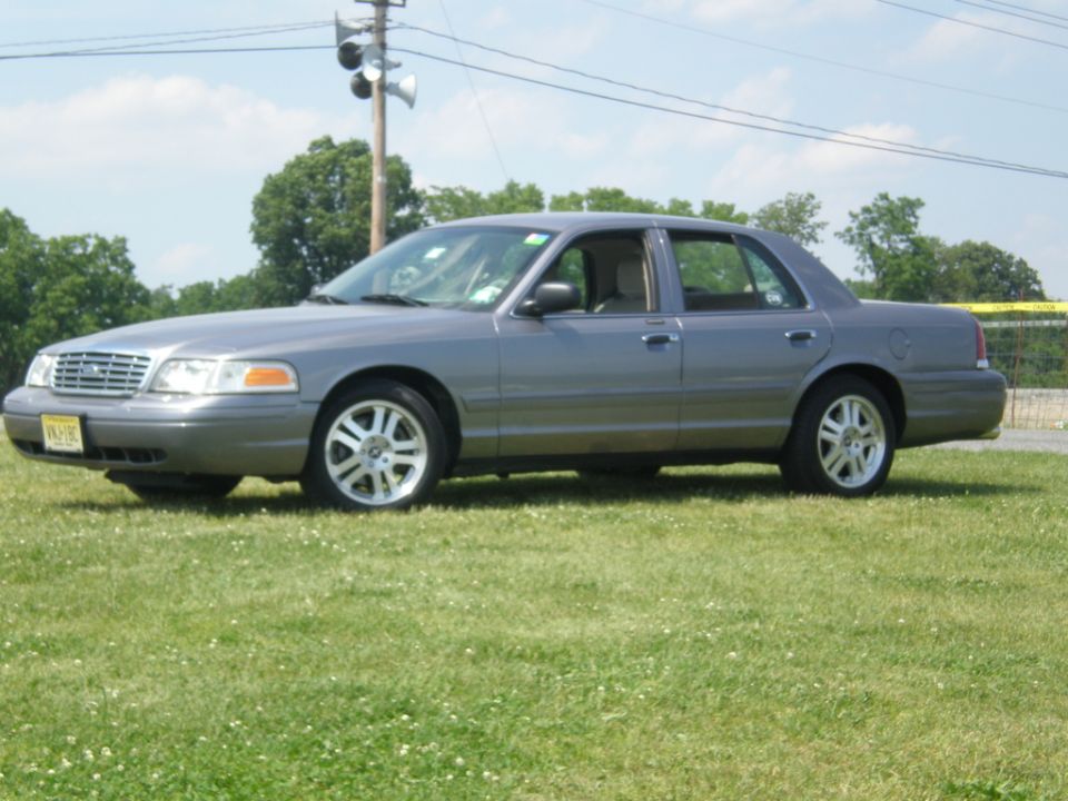 Gray sedan parked on grass, side view