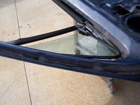 1986 Ford Bronco - This image shows a disassembled car door, focusing on the frame and vent window area.