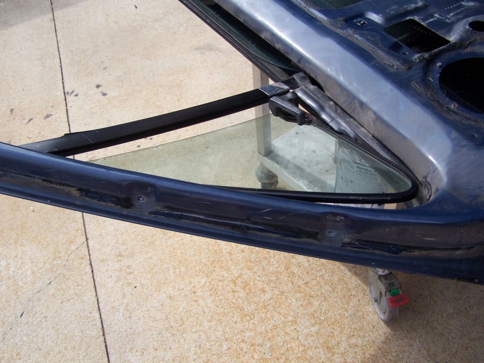 Close-up of a car door frame with a triangular vent window removed