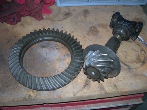 1985 Ford Bronco - Differential gears and axle housing are laid out on a workbench.