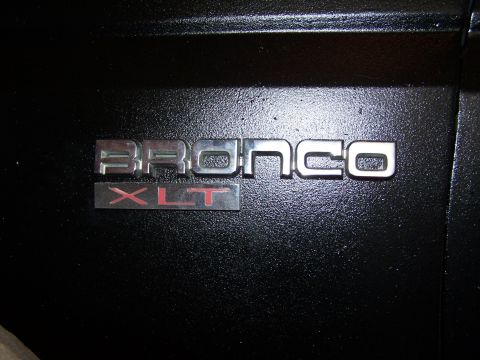 1986 Ford Bronco - Close-up of a Bronco XLT emblem, indicating a specific trim level.