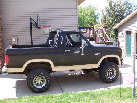 1986 Ford Bronco - Side view of a two-tone Ford Bronco with a removable top.