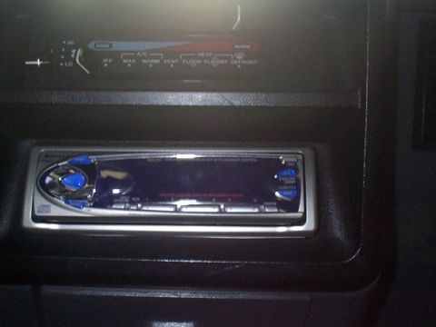 1991 Ford Bronco - Close-up of a car's dashboard showing an aftermarket stereo and climate controls.