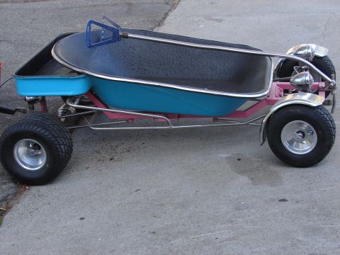 1973 Ford Ranchero - A custom-built go-kart with a blue-and-black bathtub-style body on a pink tube frame, side view, riding on polished mag wheels with knobby…