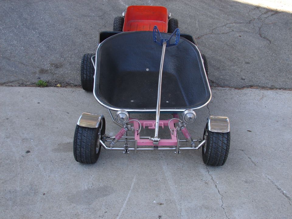 Custom pedal car with black tub body, pink front axle, chrome frame and blue steering wheel