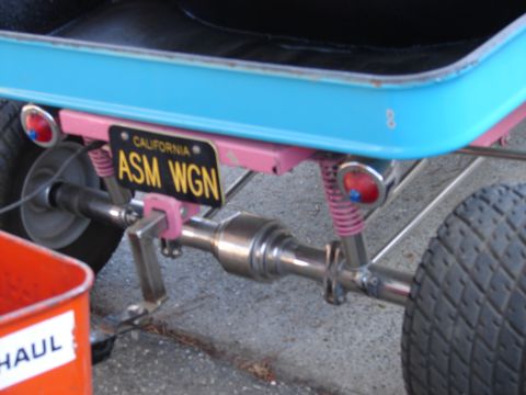1973 Ford Ranchero - Close-up of a custom vehicle's rear axle, a bright pink suspension system and a California license plate.