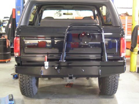 1995 Ford Bronco - The rear of a black SUV is shown, an aftermarket bumper and a spare tire carrier.