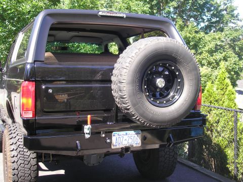 1995 Ford Bronco - Rear view of a black 1995 Ford Bronco, an aftermarket bumper and spare tire.