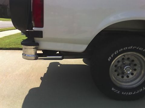 1996 Ford Bronco - Close-up of the rear side of a white Ford Bronco, highlighting the spare tire and wheel.
