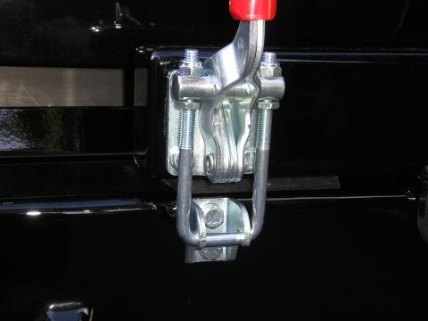 1995 Ford Bronco - A close-up view of a metal latch mechanism attached to a black surface.