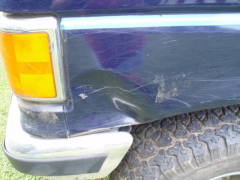 1989 Ford Bronco - This dark blue SUV shows significant damage to its rear quarter panel and bumper.