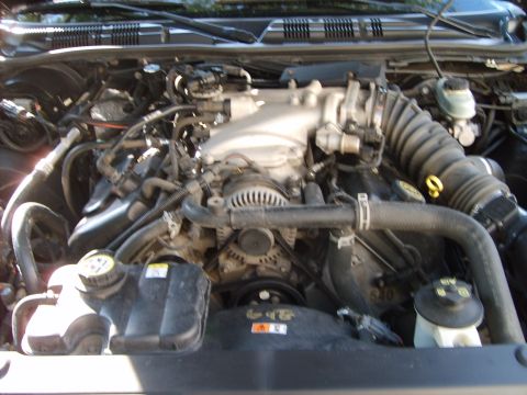 1993 Ford Crown Victoria - Engine bay of a Ford sedan photographed straight down from the front with the hood raised, showing a modular V8 with cast aluminum intake m…