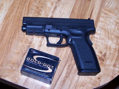 1995 Ford Bronco - A handgun and a box of ammunition are placed on a wooden surface.