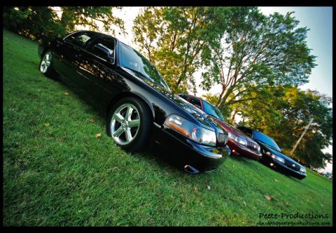 2003 Mercury Marauder - Three sedans are parked on a grassy hill, with the closest one being a black 2003 Mercury Marauder.