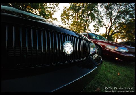 2003 Mercury Marauder - Close-up of a black 2003 Mercury Marauder's grille, with another vehicle visible in the background.