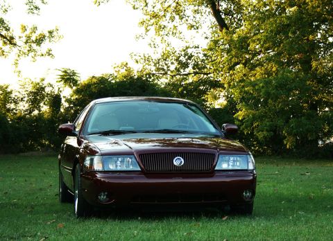 2003 Mercury Marauder - Front view of a maroon 2003 Mercury Marauder parked on a grassy lawn with trees.