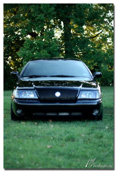 2003 Mercury Marauder - Front view of a black 2003 Mercury Marauder parked on grass with trees in the background.