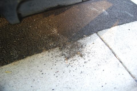 2002 BMW M3 - Close-up of asphalt and concrete curb with dirt debris. Supermotors.net logo is visible.