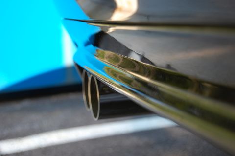 2002 BMW M3 - Close-up of chrome exhaust pipes on a vehicle with a blue rear panel.