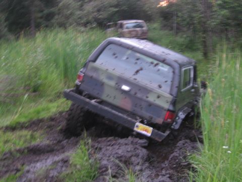 1990 Ford F-250 - This vehicle is stuck in the mud, with another vehicle visible in the background.