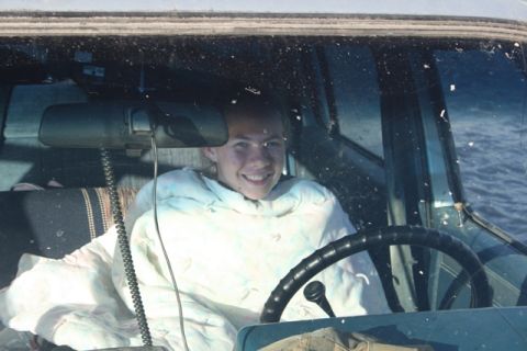 1990 Chevrolet Suburban - A person sits in the interior of a vehicle, wrapped in a blanket.