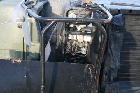 1990 Chevrolet Suburban - Close-up view of the engine bay and protective roll cage structure on a utilitarian vehicle.