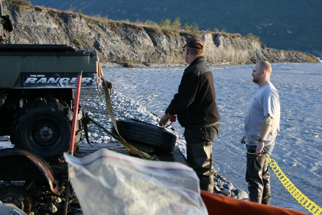 Polaris Ranger ATV with 'RANGER' visible on the side, next to a river with two men