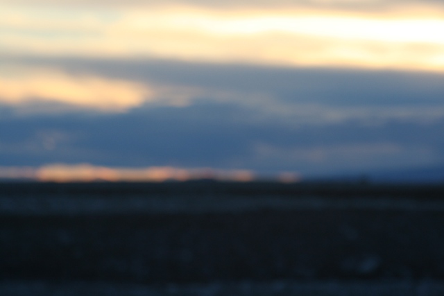 Blurry landscape with clouds at sunset or sunrise.