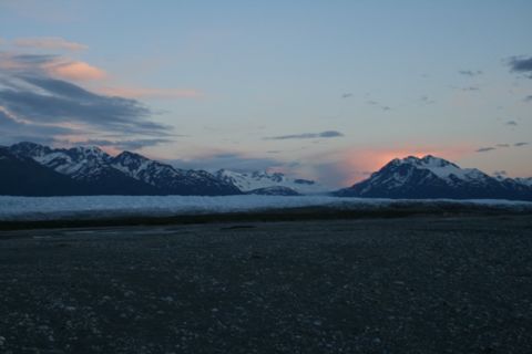 1990 Chevrolet Suburban - A wide shot of a mountainous landscape at dusk. Snow-capped mountains are visible in the background, with a glacier in the mid-ground and a…