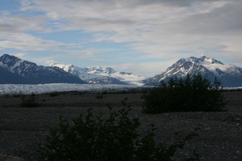 1990 Chevrolet Suburban - A wide scenic view of snow-capped mountains and a glacier under a cloudy sky.
