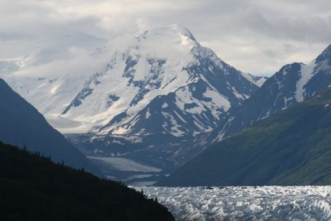 1990 Chevrolet Suburban - A vast glacial valley with snow-capped mountains under a cloudy sky.