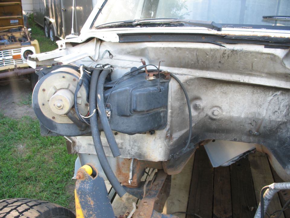 White Ford E250 van engine bay with brake booster, hoses, and wiring visible.