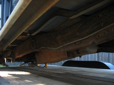 1988 Ford E250 - The underside of a vehicle is shown, with focus on the frame and suspension parts.