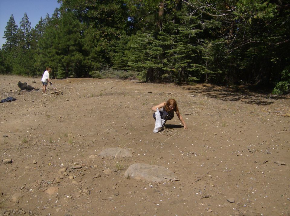 Two people in a clearing with trees.