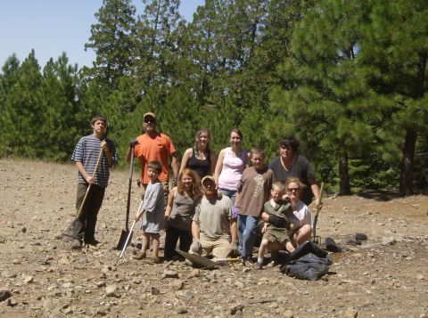 1986 Ford Bronco - A group of eleven people, including adults and children, are posing for a photo outdoors in a wooded, rocky area. They appear to be dressed…
