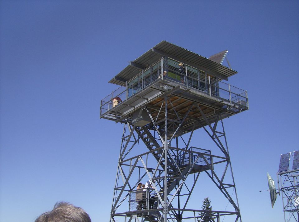 Fire lookout tower against a clear blue sky.